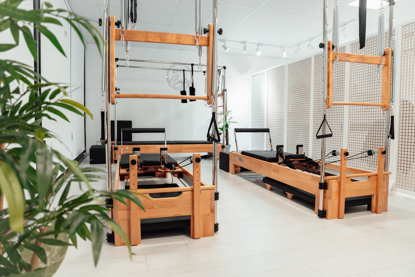 A bright reformer Pilates studio with wooden reformers and plants