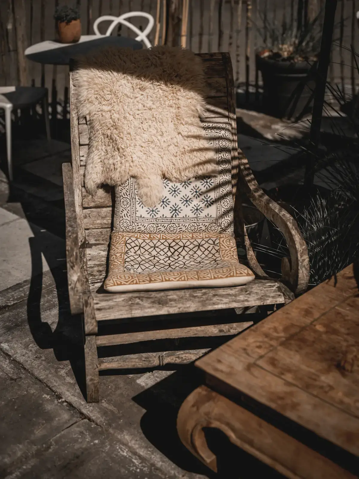 The Fjord lounge chair in oak with a folded blanket, in afternoon sun