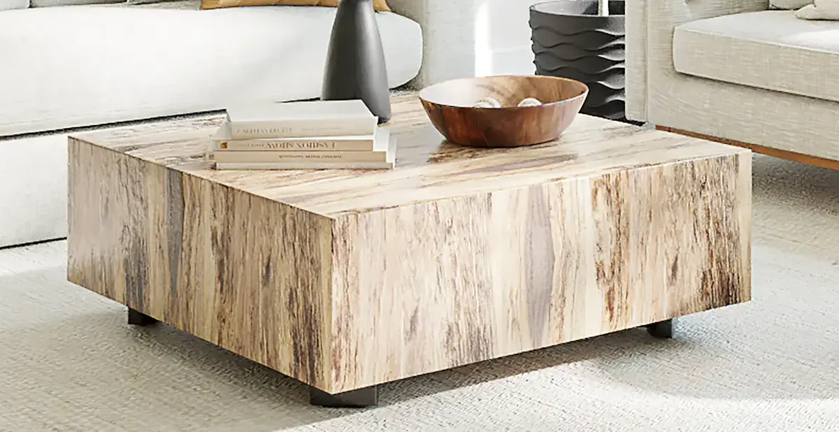 The square Sund coffee table in pale solid wood with books and a wooden bowl on top