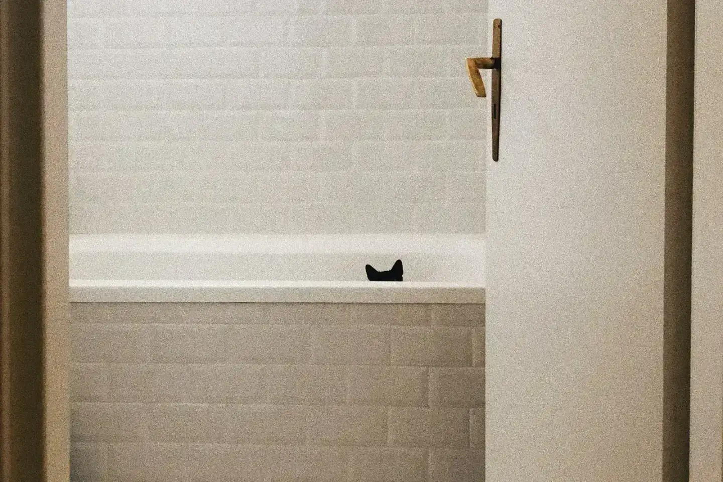 Before: a plain bathroom with white brick-pattern tiles around a built-in bath