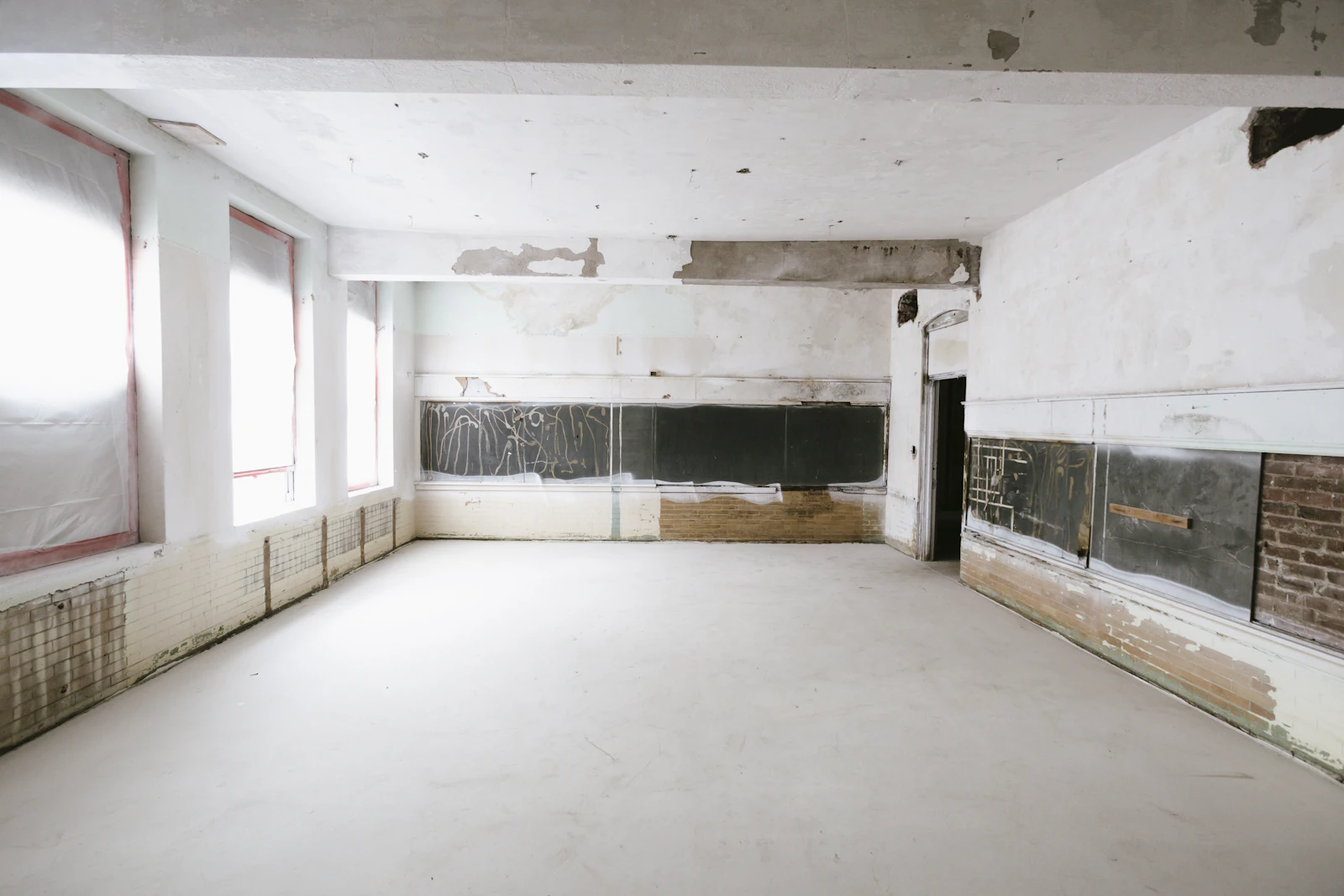 Before: a stripped room mid-renovation with bare plaster walls and old radiators