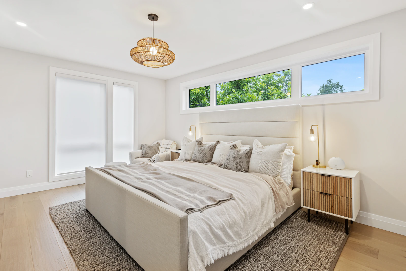 After: a restful bedroom with a white upholstered bed, soft linen and windows above