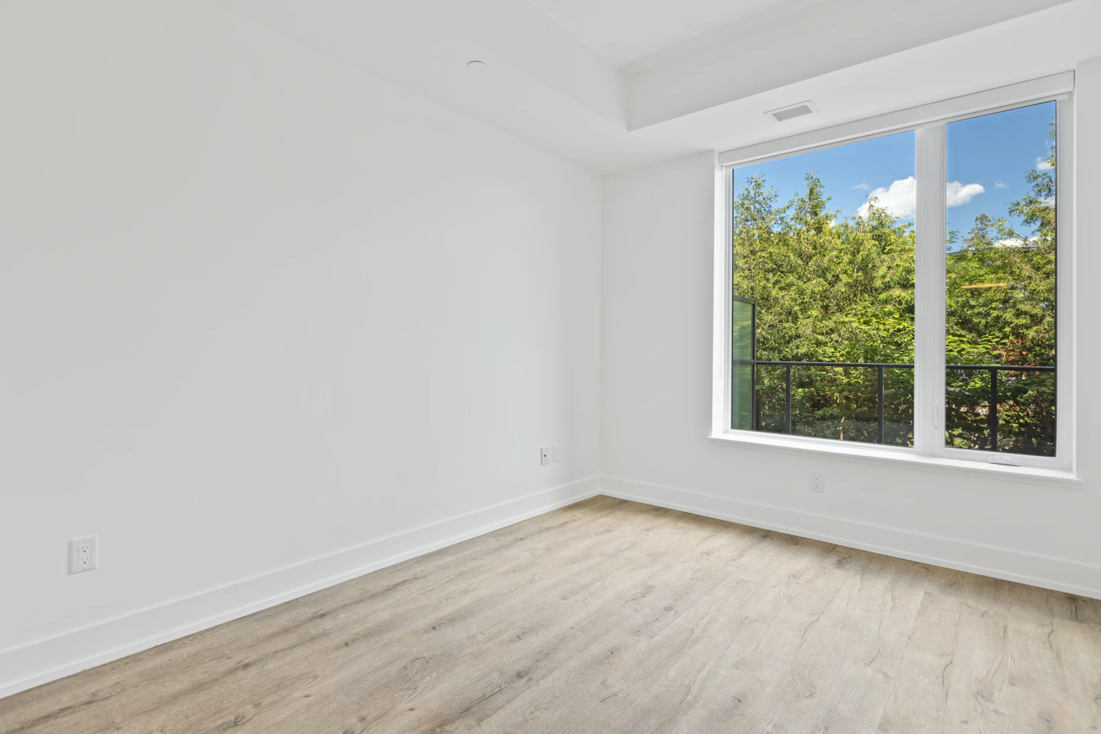 Before: an empty white bedroom with a wooden floor and one window