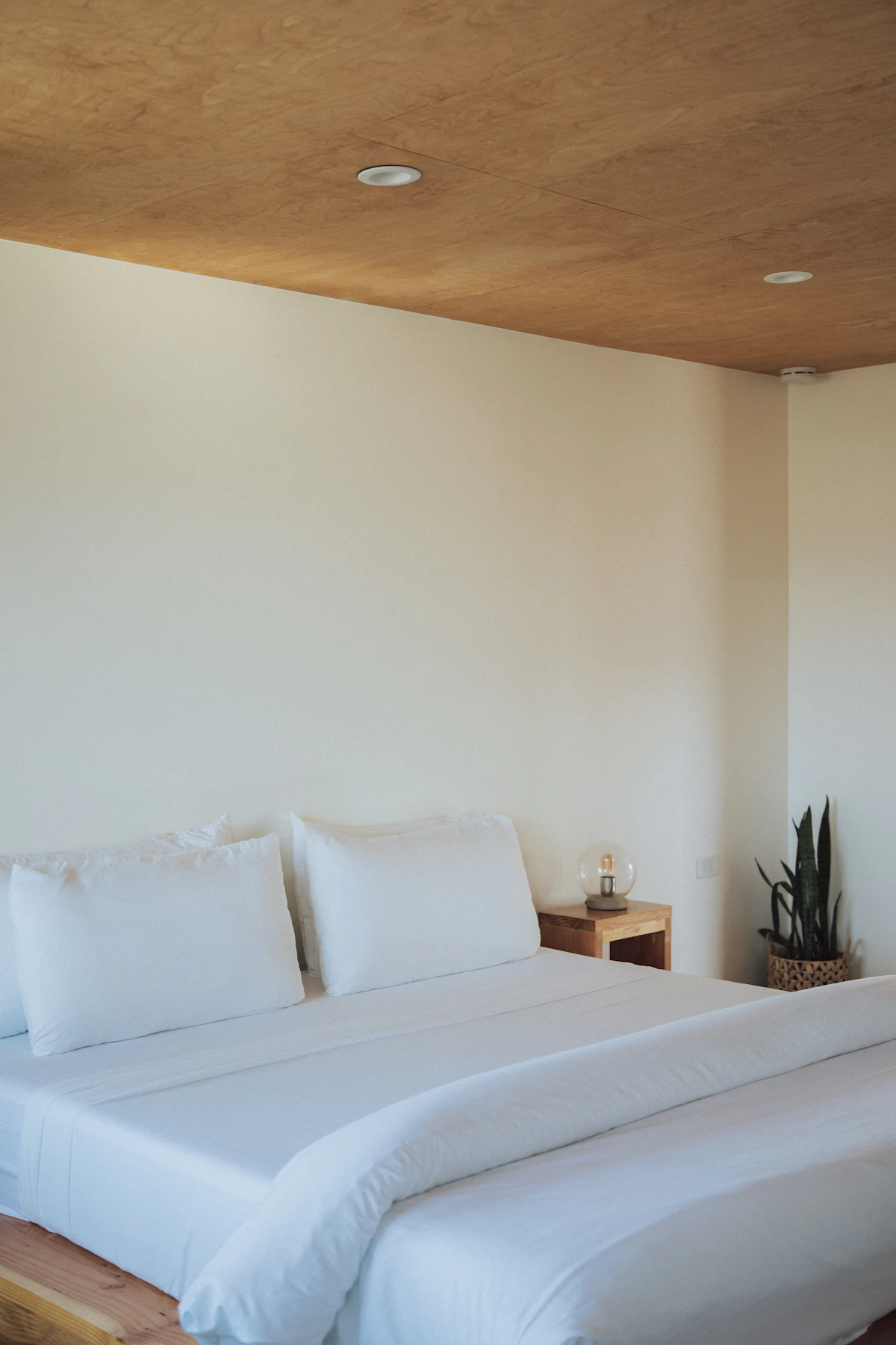 A bed with crisp white sheets and pillows in warm morning light