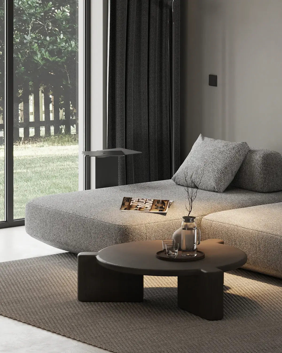 A deep grey modular sofa with a coffee table beside large garden windows