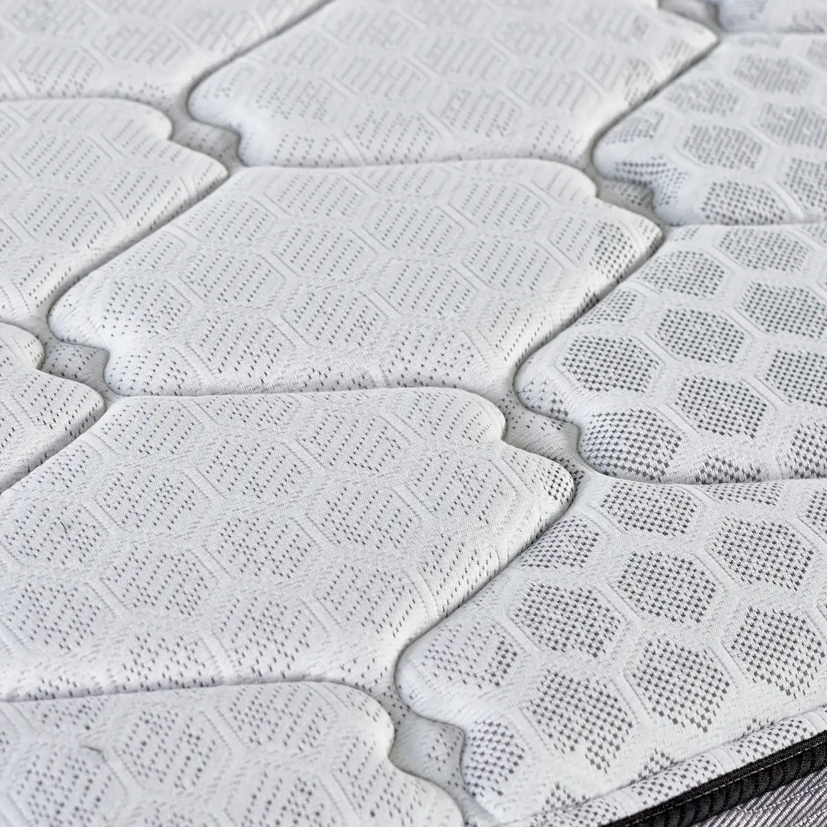 Close-up of the Hybrid mattress's white quilted cover with a hexagonal stitch pattern